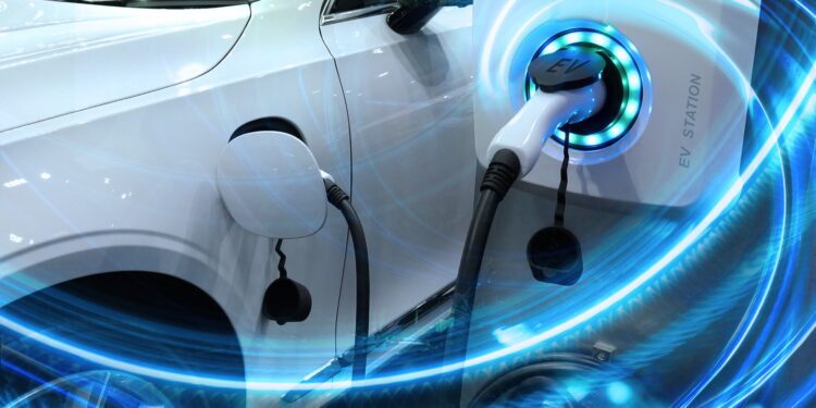 EV Car or Electric vehicle at charging station with the power cable supply plugged in on blurred nature with blue energy power effect. Eco-friendly sustainable energy concept.
